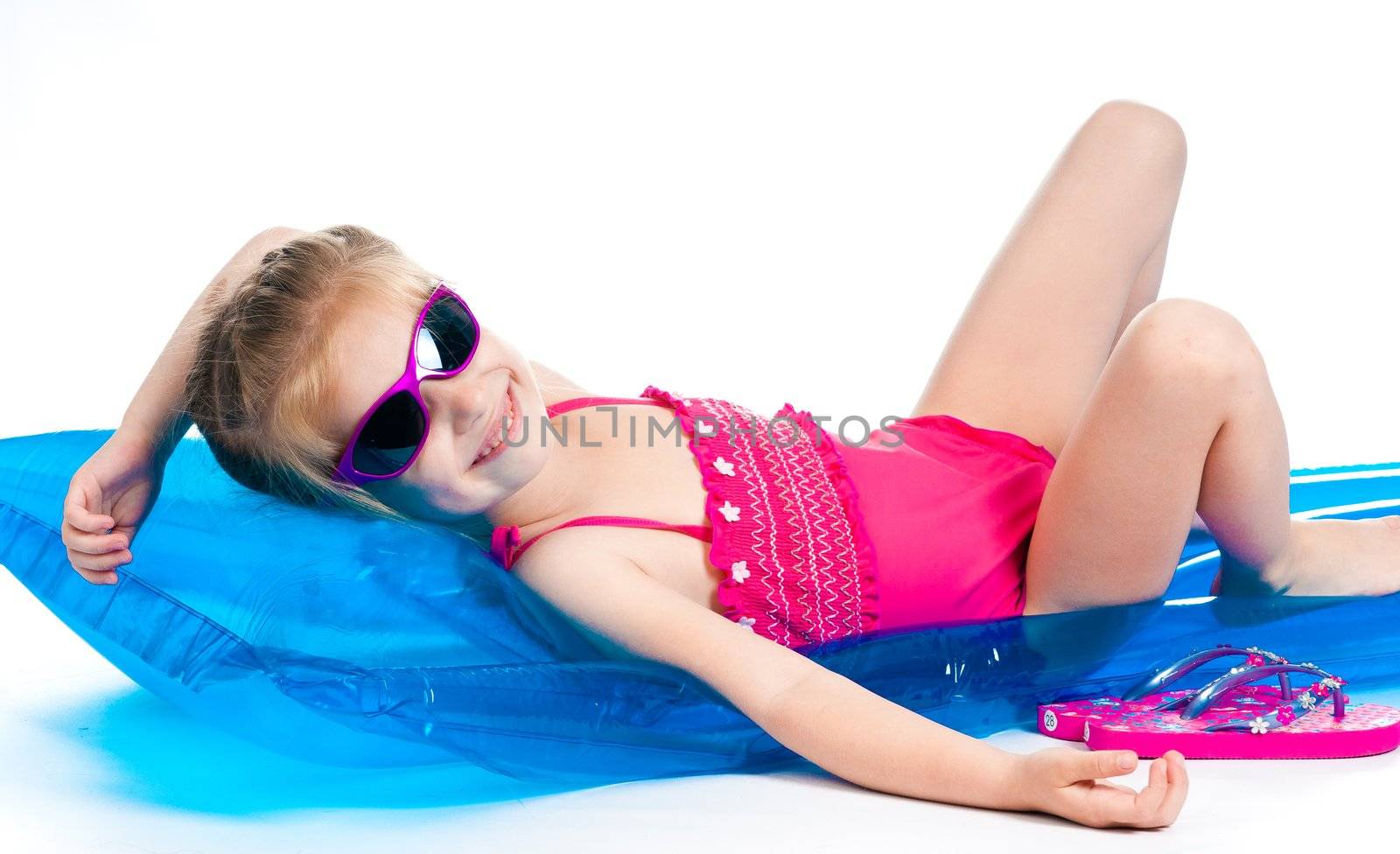 cute little girl in a swimming suit on an inflatable mattress
