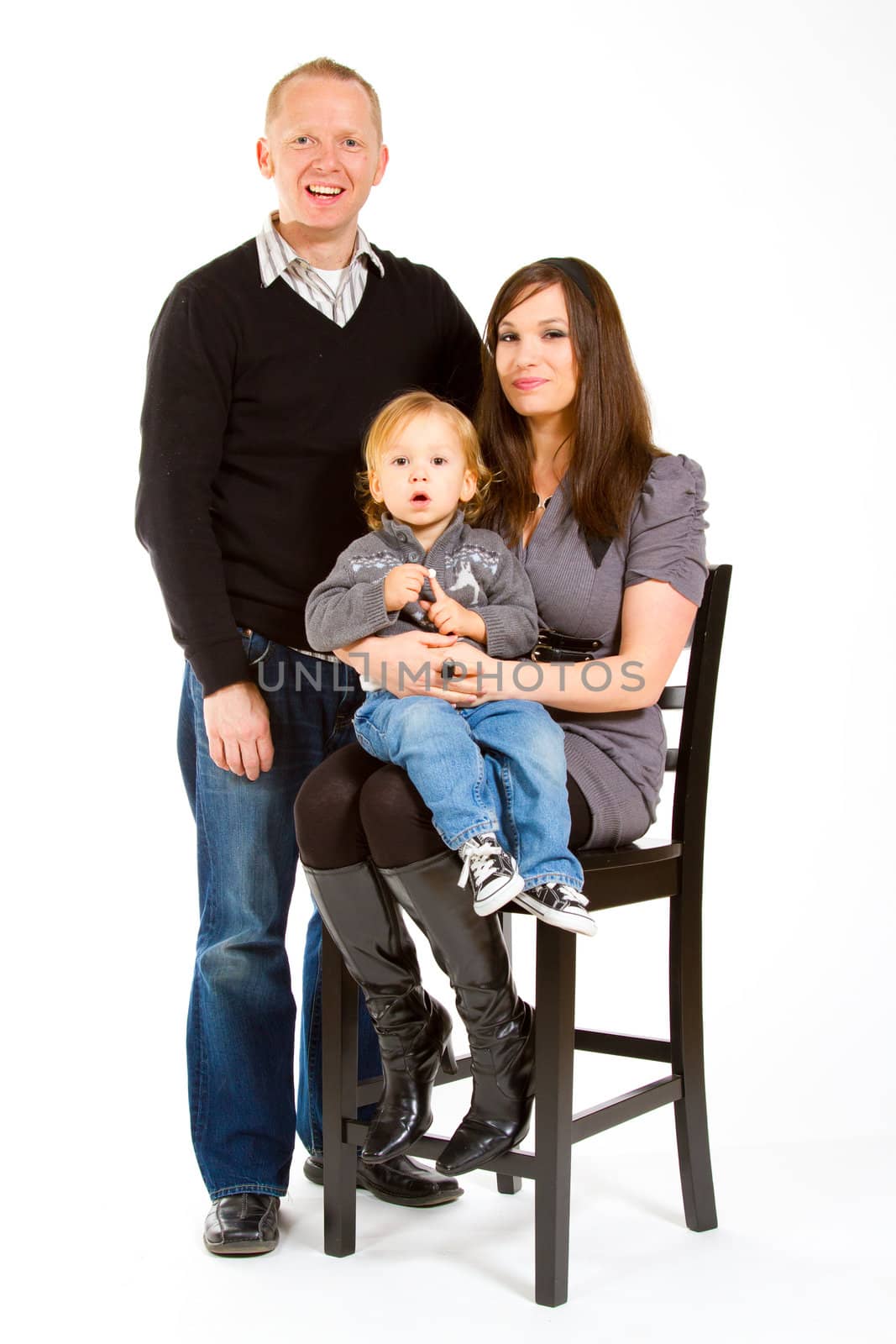 A small family of three portrait in a studio with a white background.