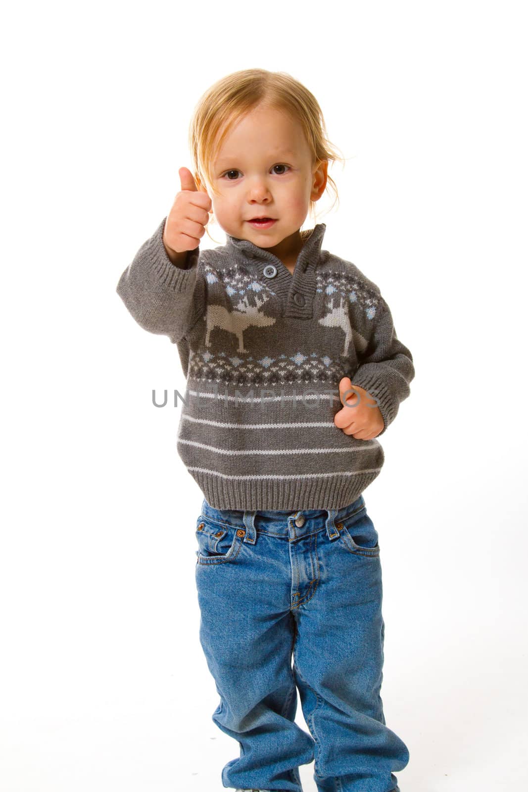 A young boy in a sweater in the studio for a portrait against a white background.