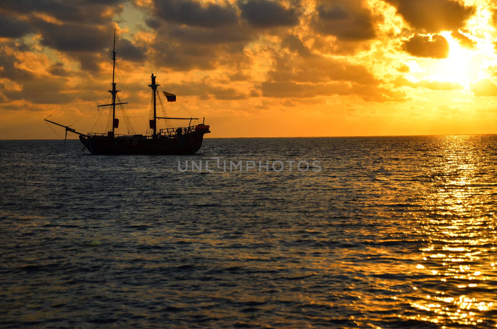Orange sunrise with pirate ship on Caribbean Sea in San Andres, Colombia