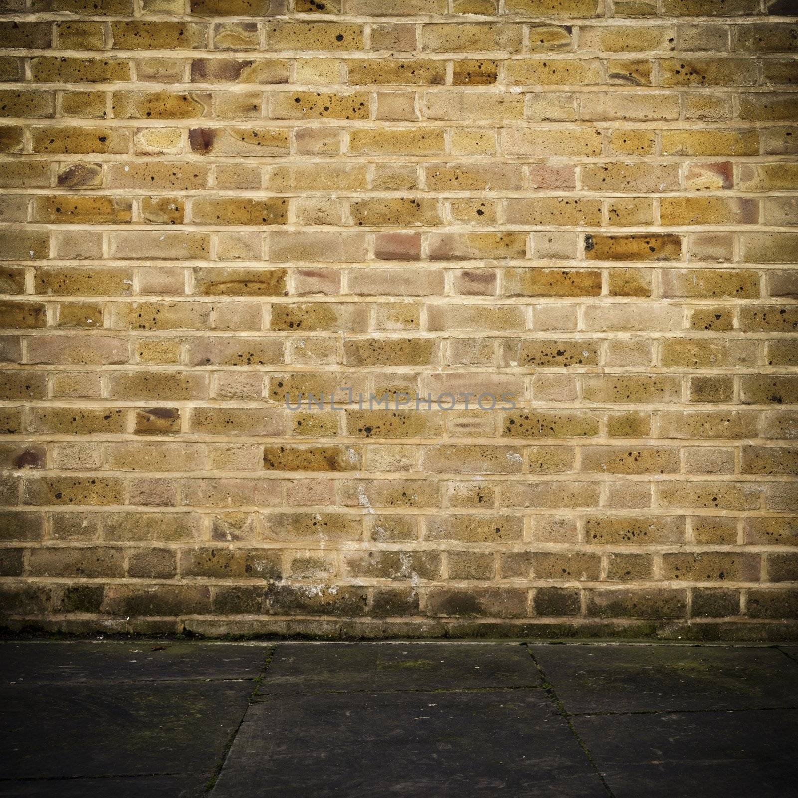 Old brick wall and dark stone floor, square photograph with vignette