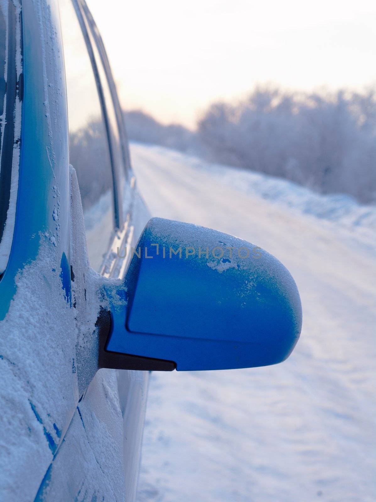 car with outside mirror .Snowy road surface