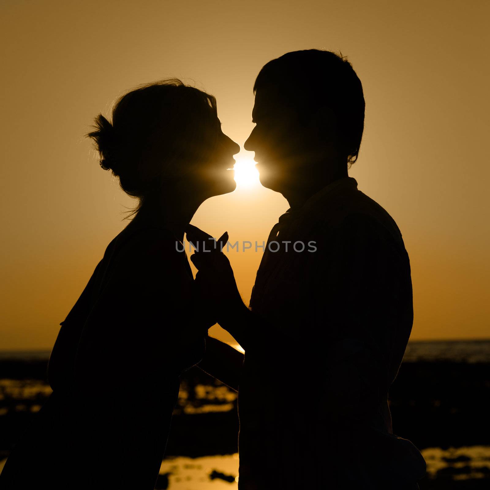 Sillhouette of kissing couple at sunset by iryna_rasko