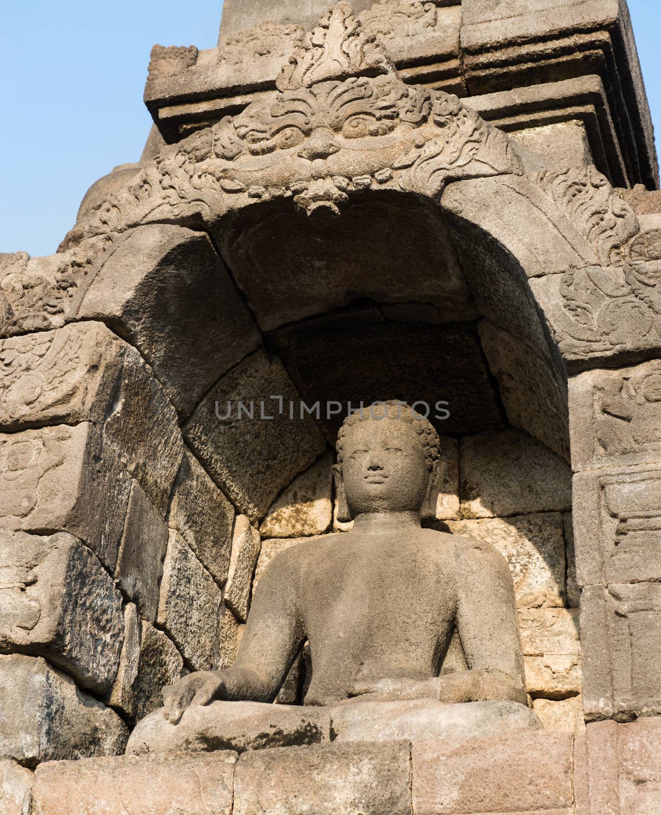 Buddha statue in niche in Borobudur, or Barabudur, temple Jogjakarta, Java, Indonesia at sunrise. It is a 9th-century Mahayana temple and the biggest  Buddhist Temple in Indonesia.