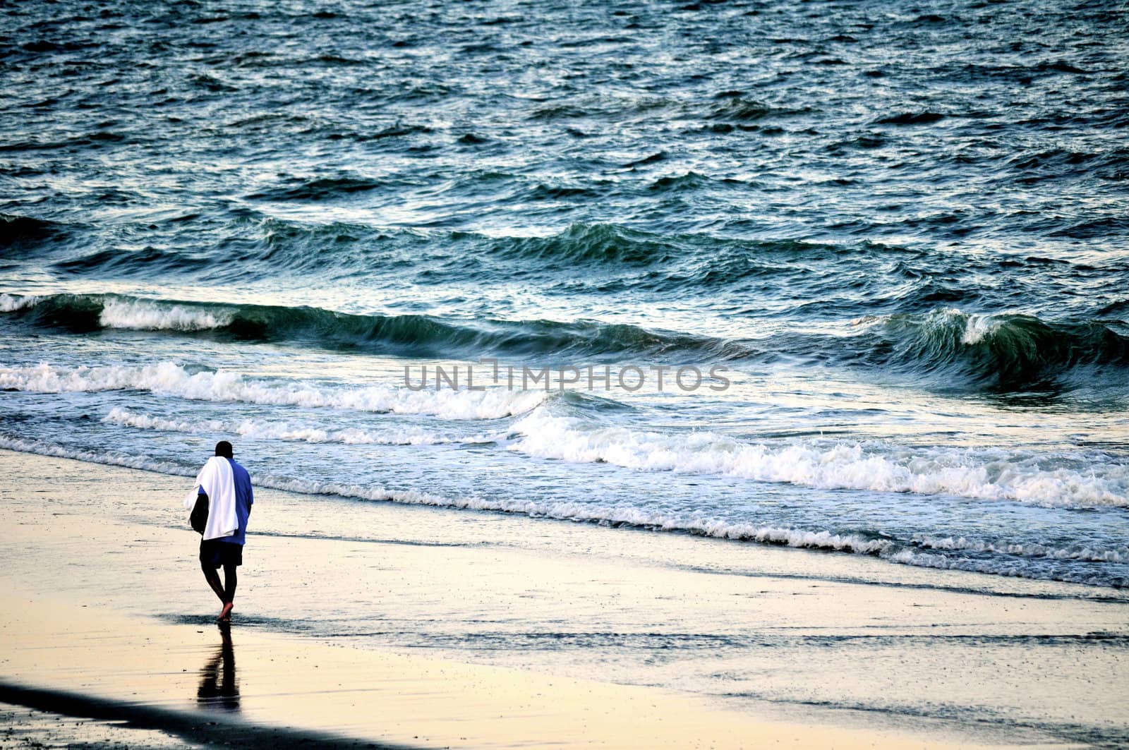 Man walking on the beach by RefocusPhoto