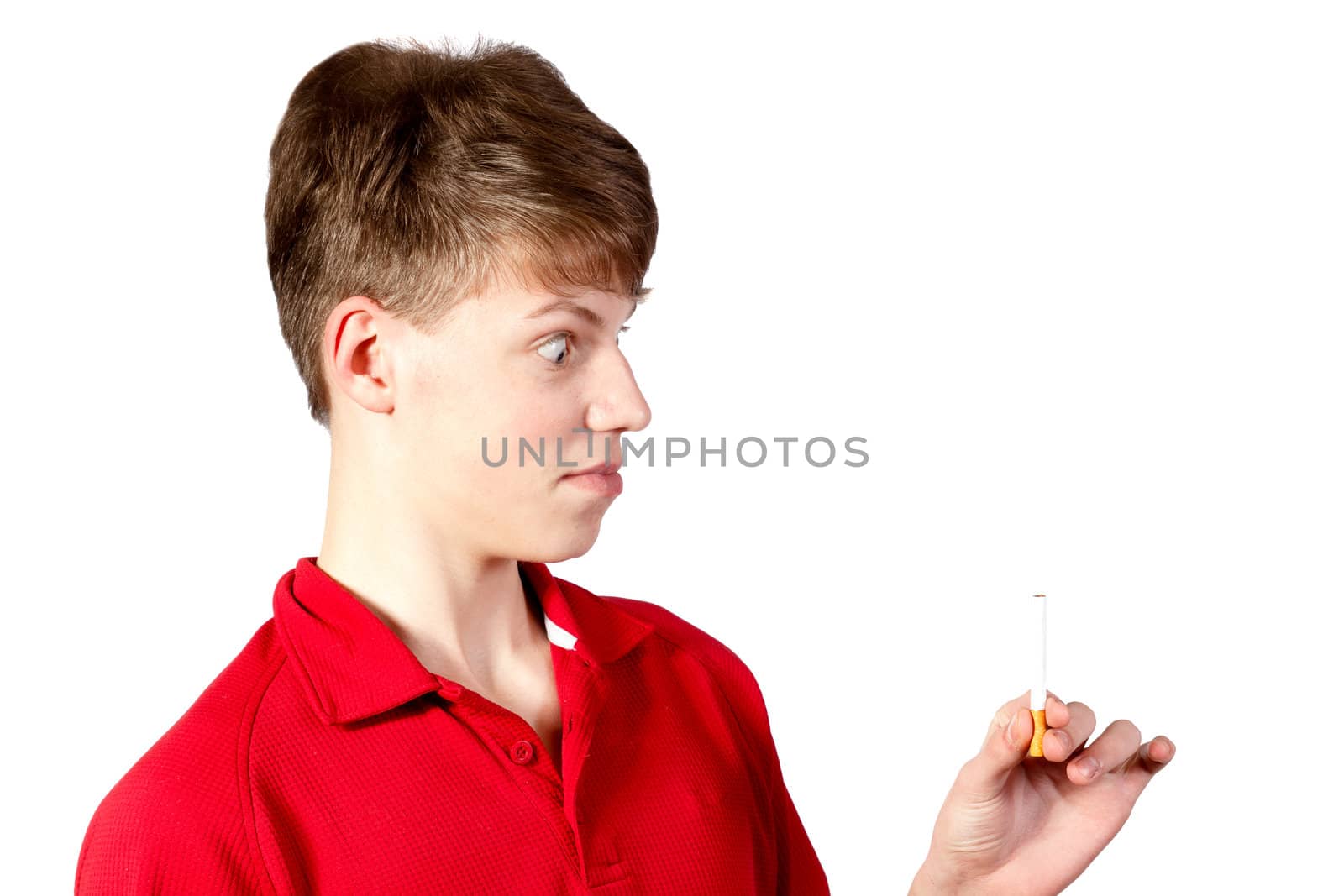 Thoughtful young boy with wide eyes looks at a cigarette