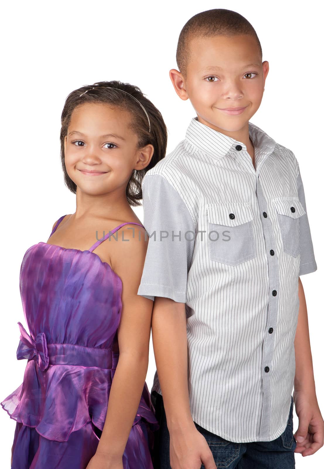 A brother and sister smile happily whilst standing close to each other.