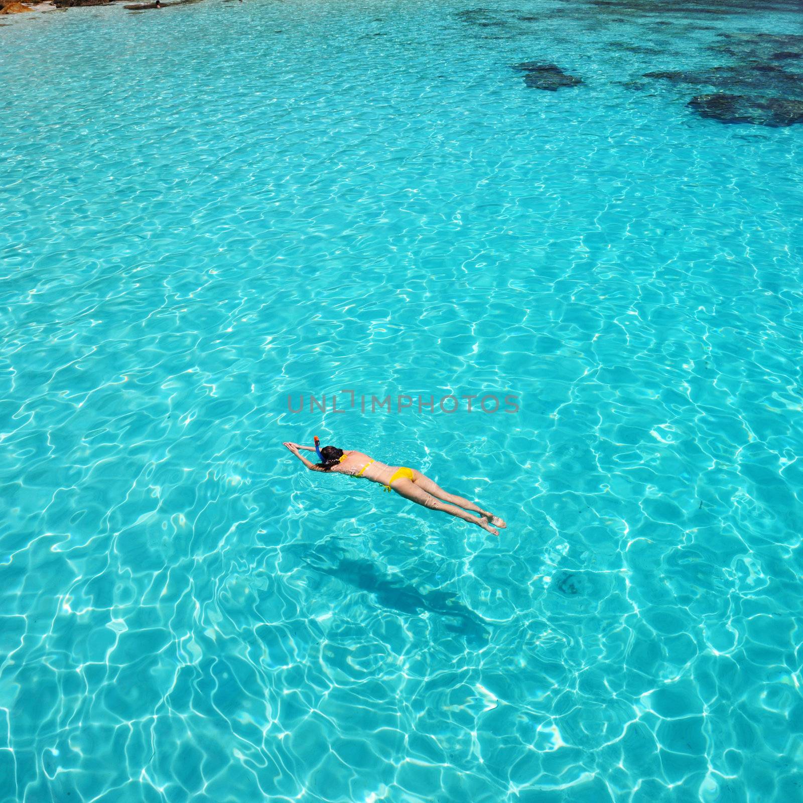 Woman snorkeling in crystal clear turquoise water at tropical beach