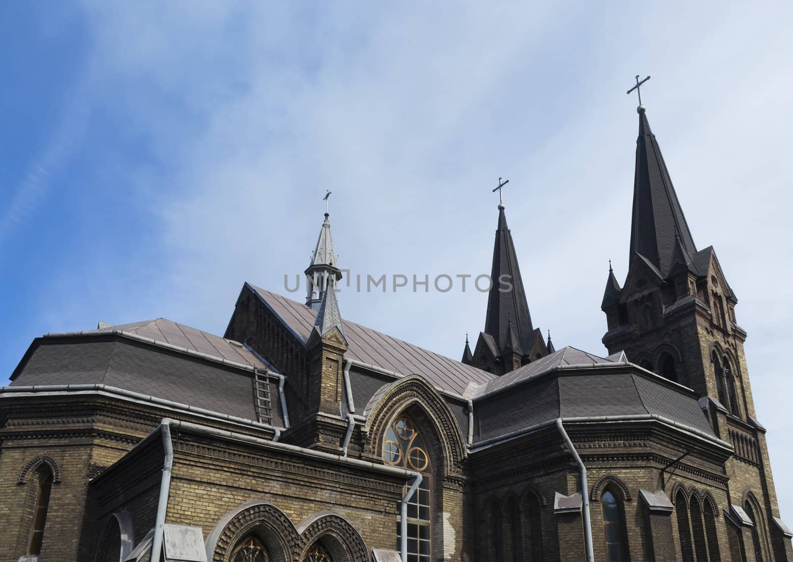 Rear side view of the upper part of the Catholic church in the summer sunlight.