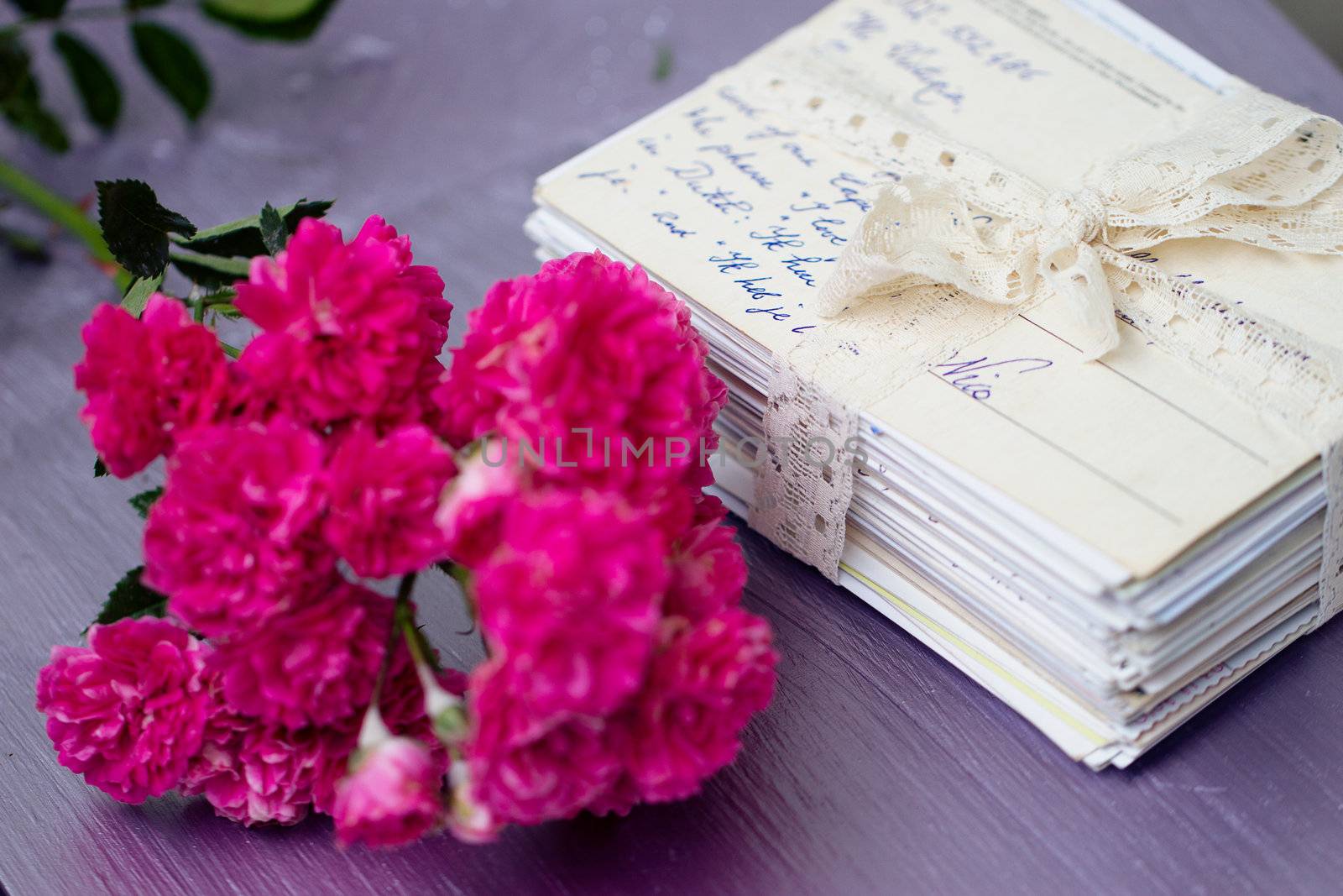 stack of old letters tied with lace ribbon with roses