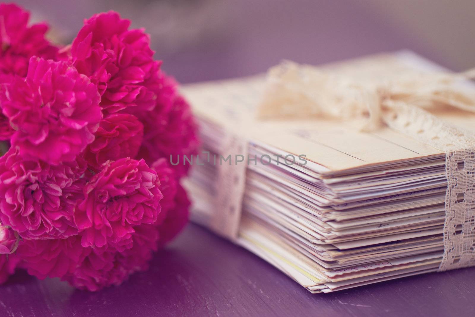 stack of old letters tied with lace ribbon with roses