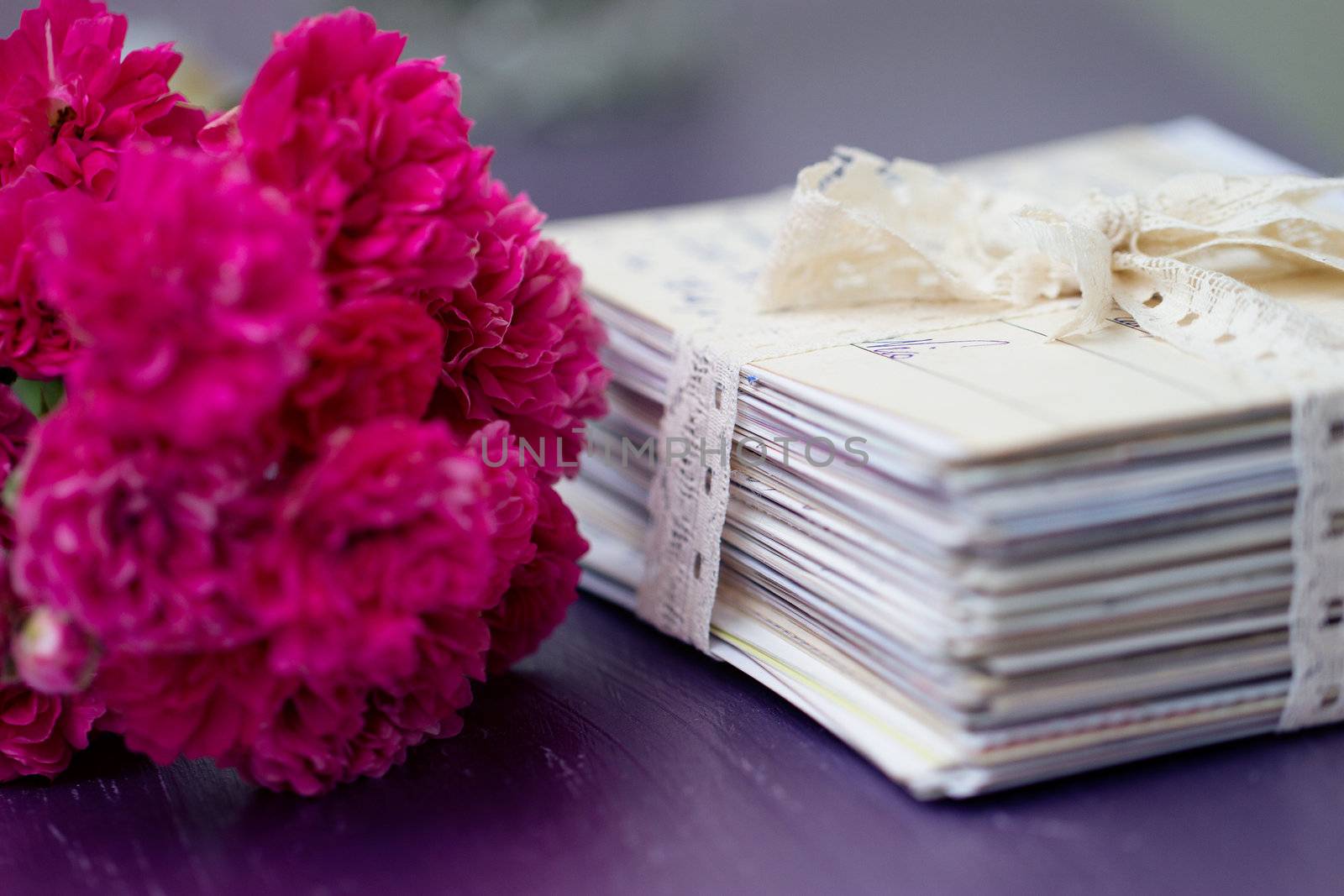 stack of old letters tied with lace ribbon with roses
