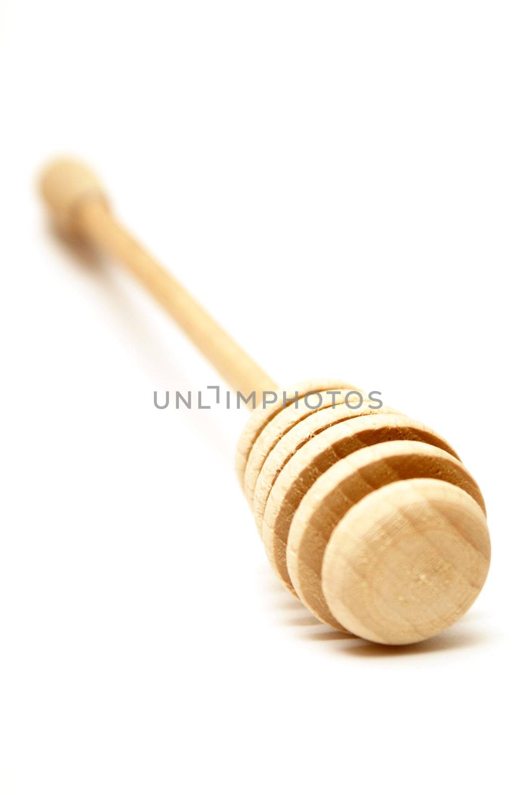 A shallow DOF shot of a handmade wooden honey stick.