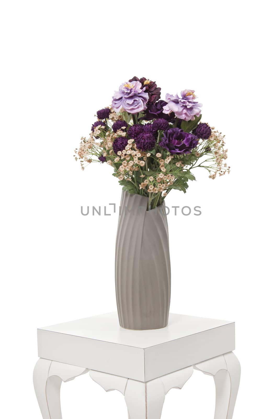 Purple flowers in glass vase on the white table