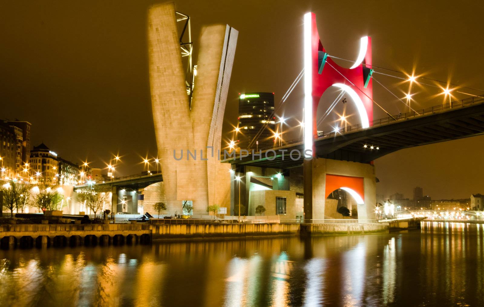 Nightview of Princes of Spain bridge, better known as La Salve bridge, over tne Nervión river in Bilbao, Spain. The commemorative red arc was designed by french artist Daniel Buren in 2007