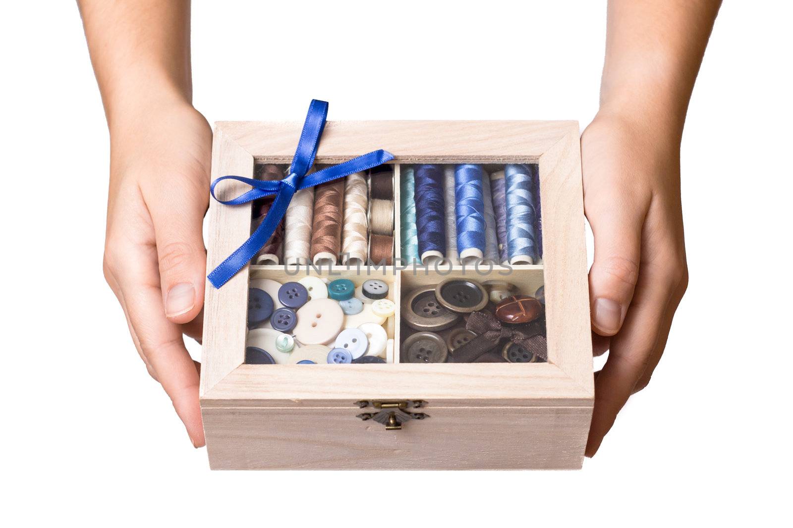 Pretty female hands show wooden sewing box