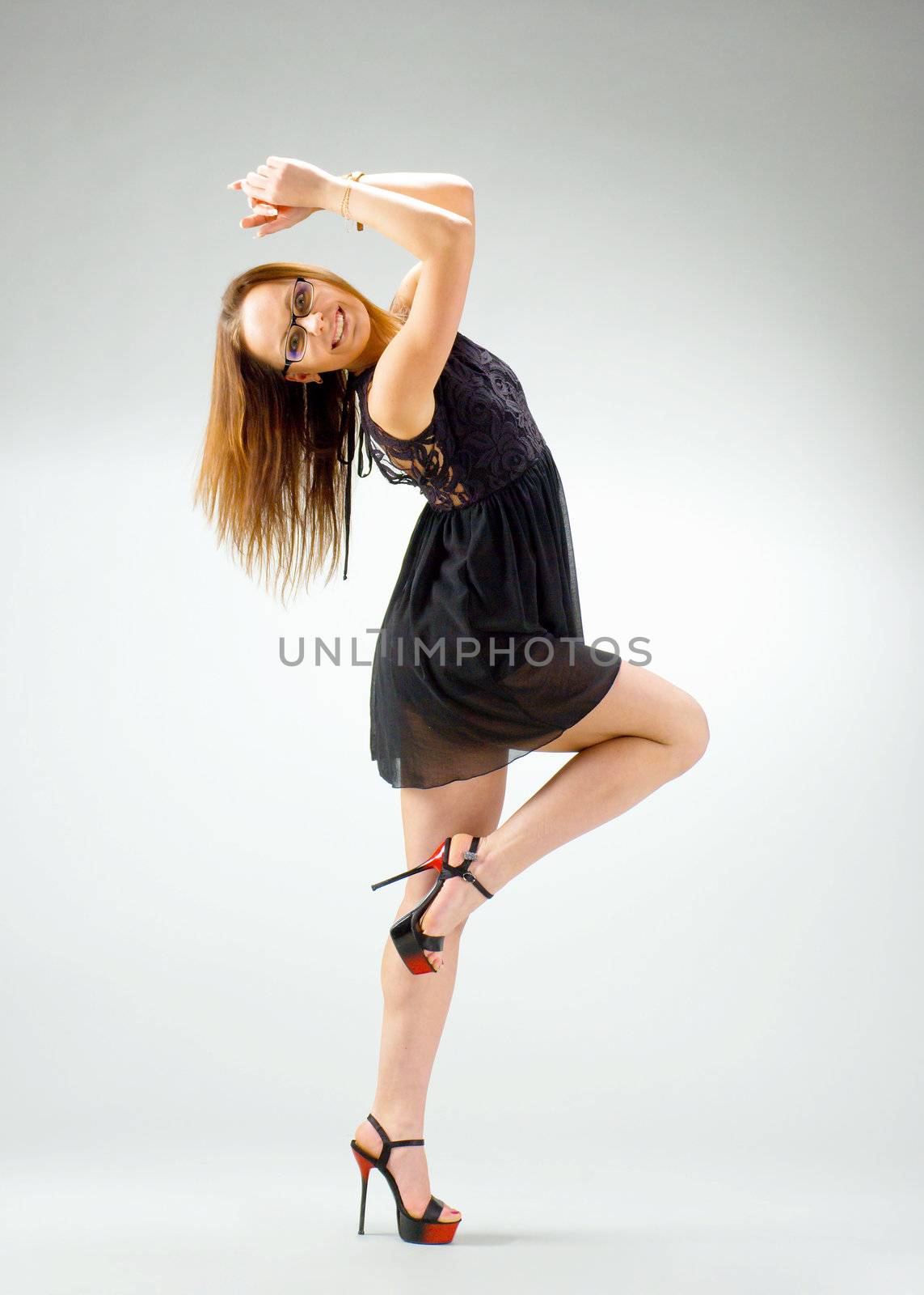 merry dancingl sexy brunette girl  on  gray background 