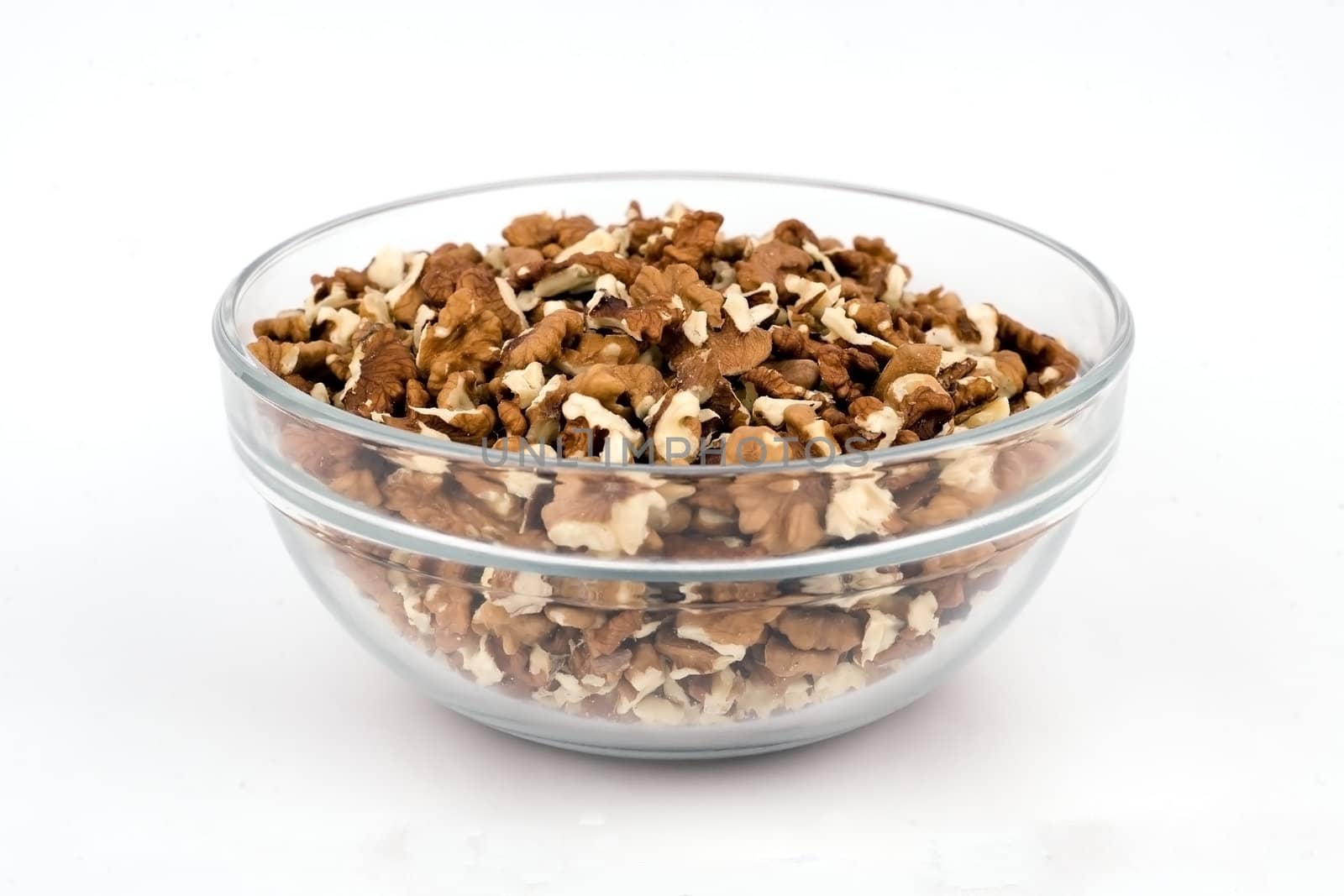 Walnuts close-up in a clear glass vase on a white background