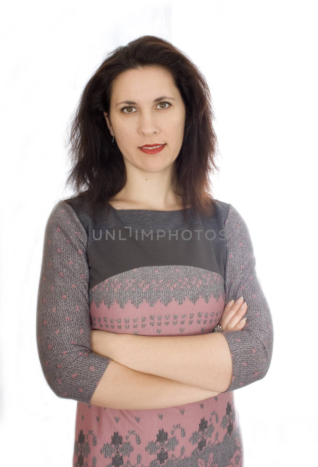 Beautiful European young woman standing with her hands folded against white background