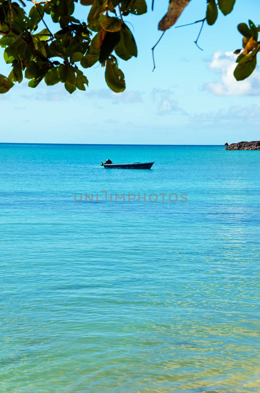 Vertical shot of blue boat on turquoise water in Caribbean Sea in San Andres y Providencia, Colombia