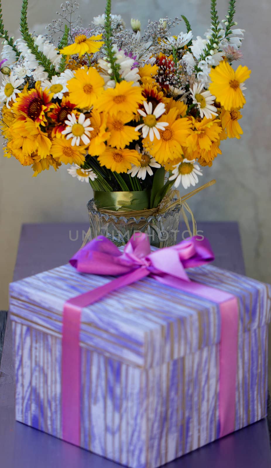 Bouquet of yellow wildflowers near the holiday gift