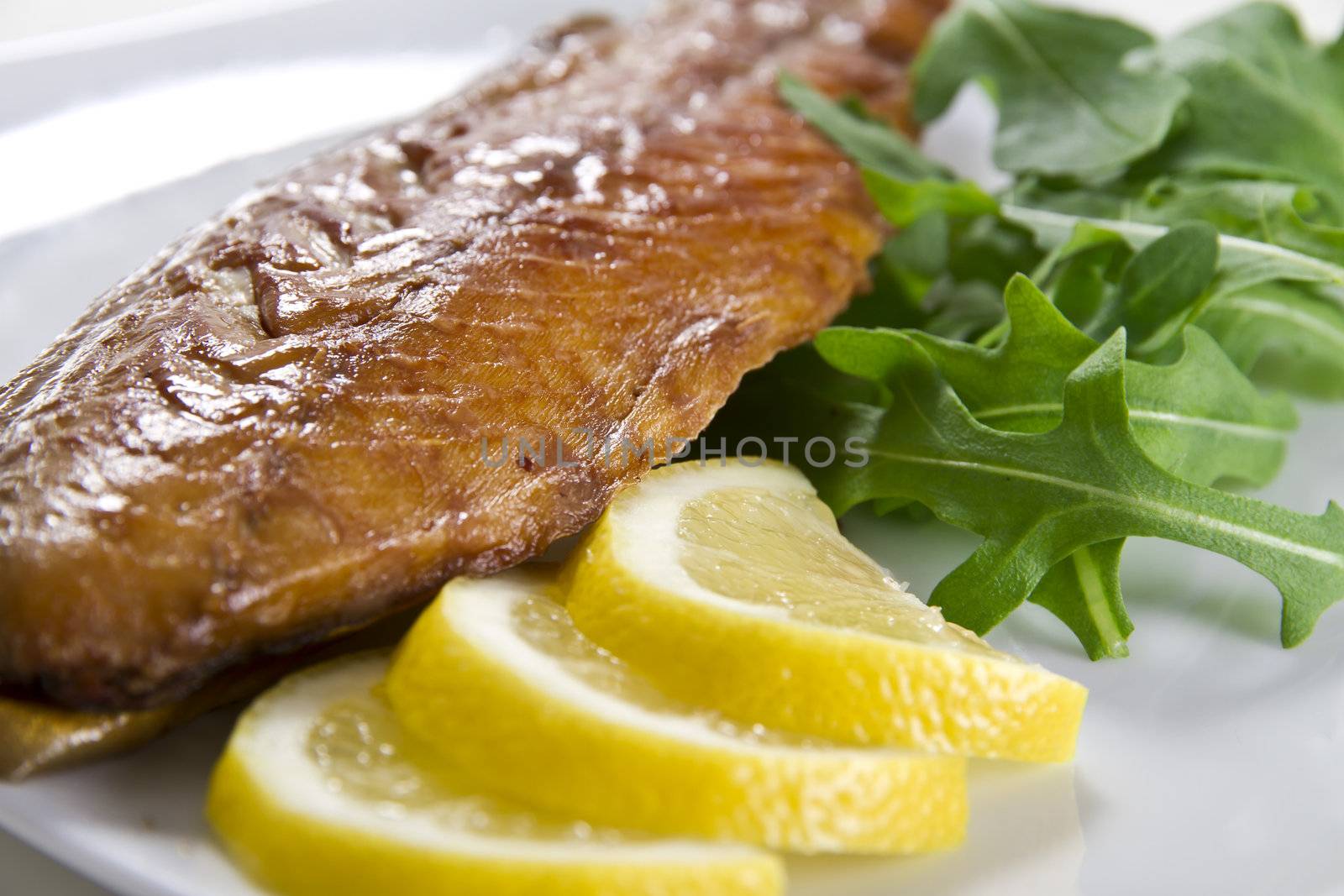 Smoked mackerel fish with lemon and salad