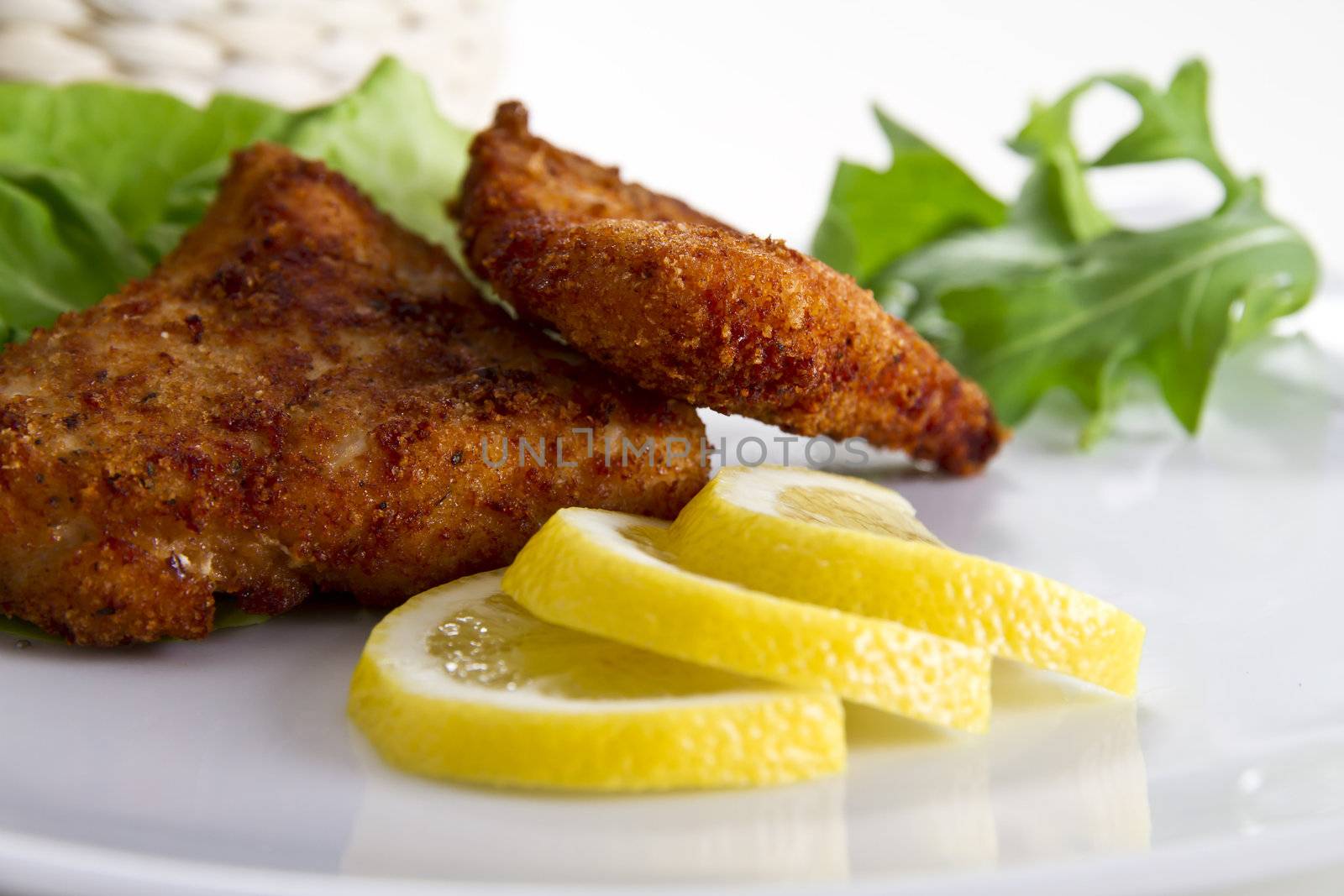 Breaded meat with lemon and salad