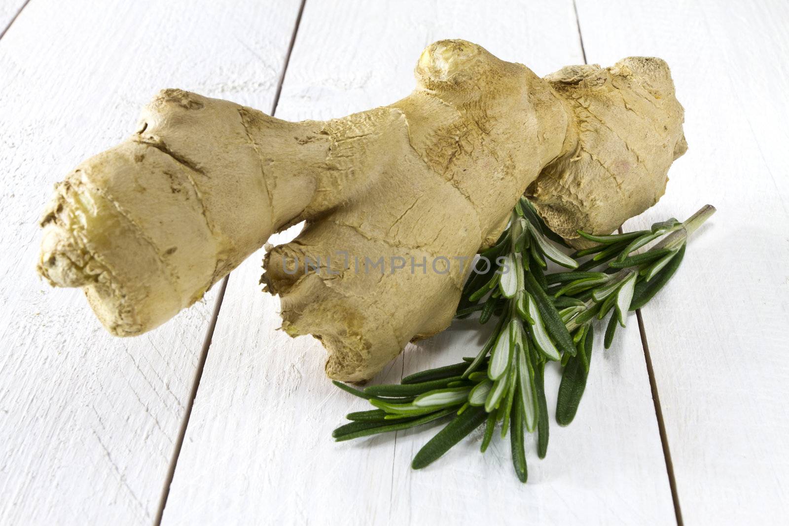 Fresh ginger and rosemary on white wooden table