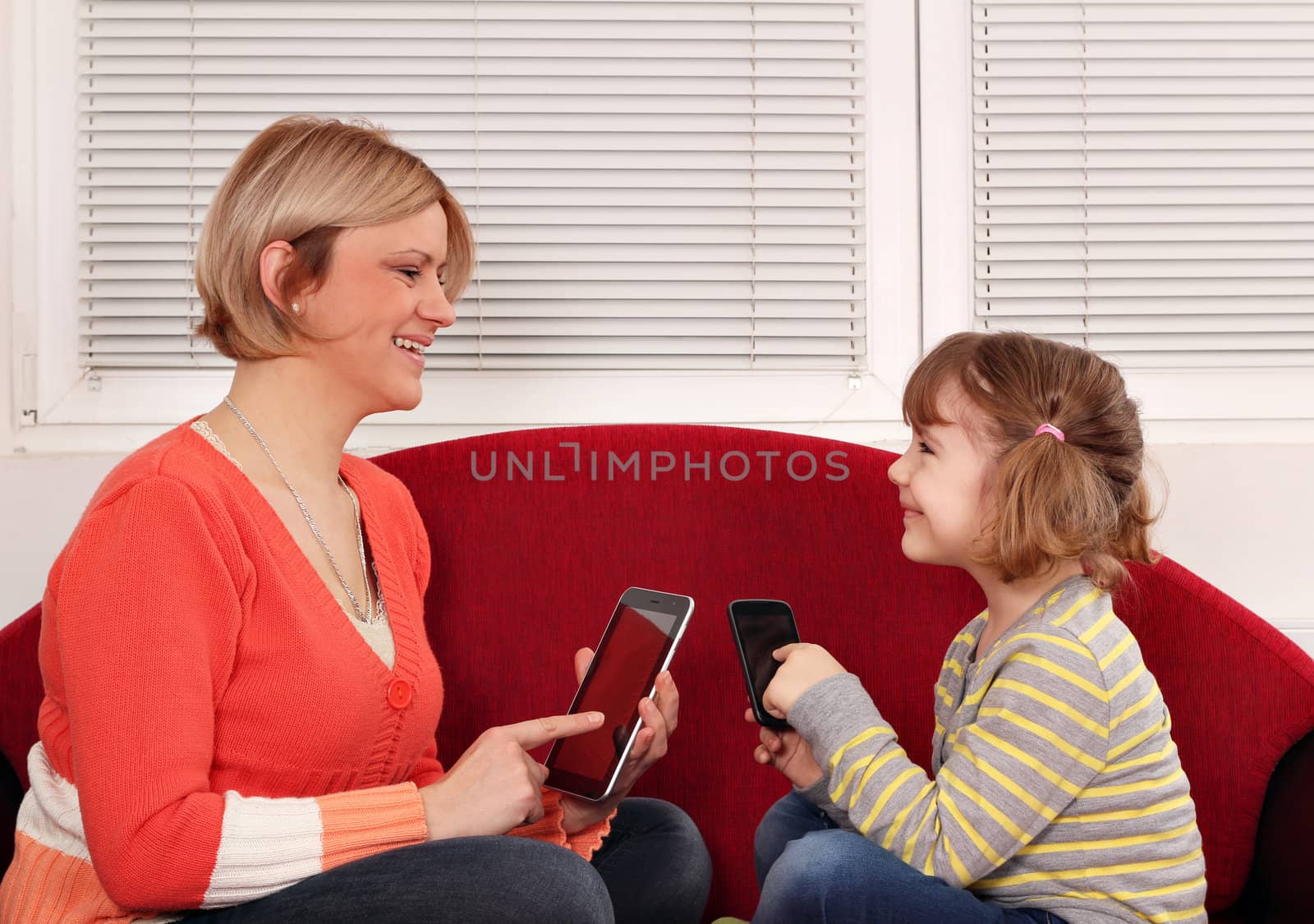 mother and daughter with tablet and smart phone by goce