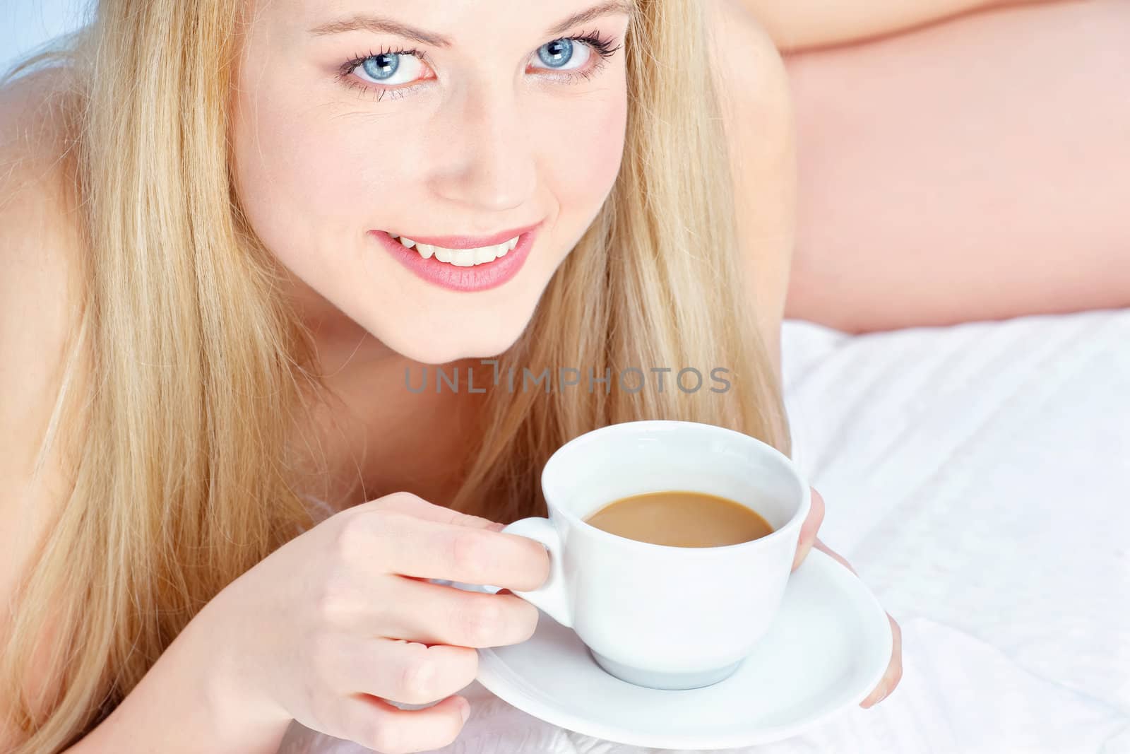 woman drinking coffee in bed by imarin