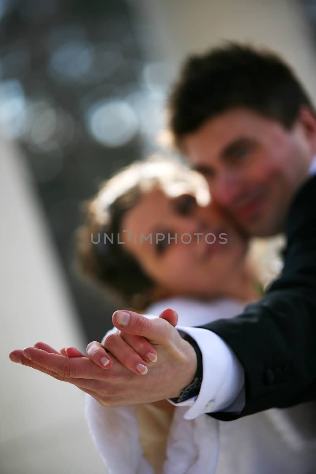 Dance of a newly-married couple. Hands in a zone of sharpness, the rest is dim