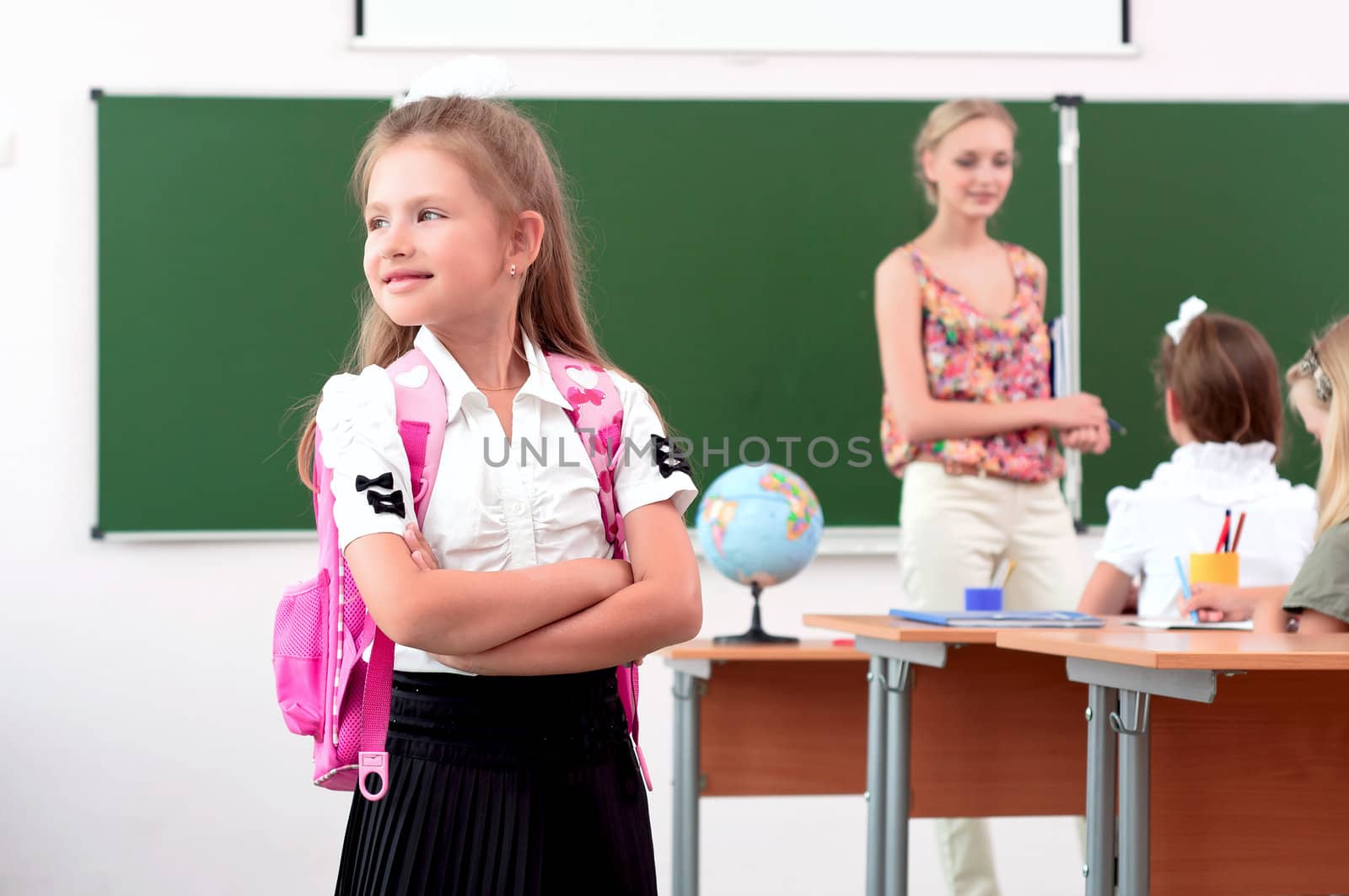 portrait of schoolgirl with a school backpack, looking out the window