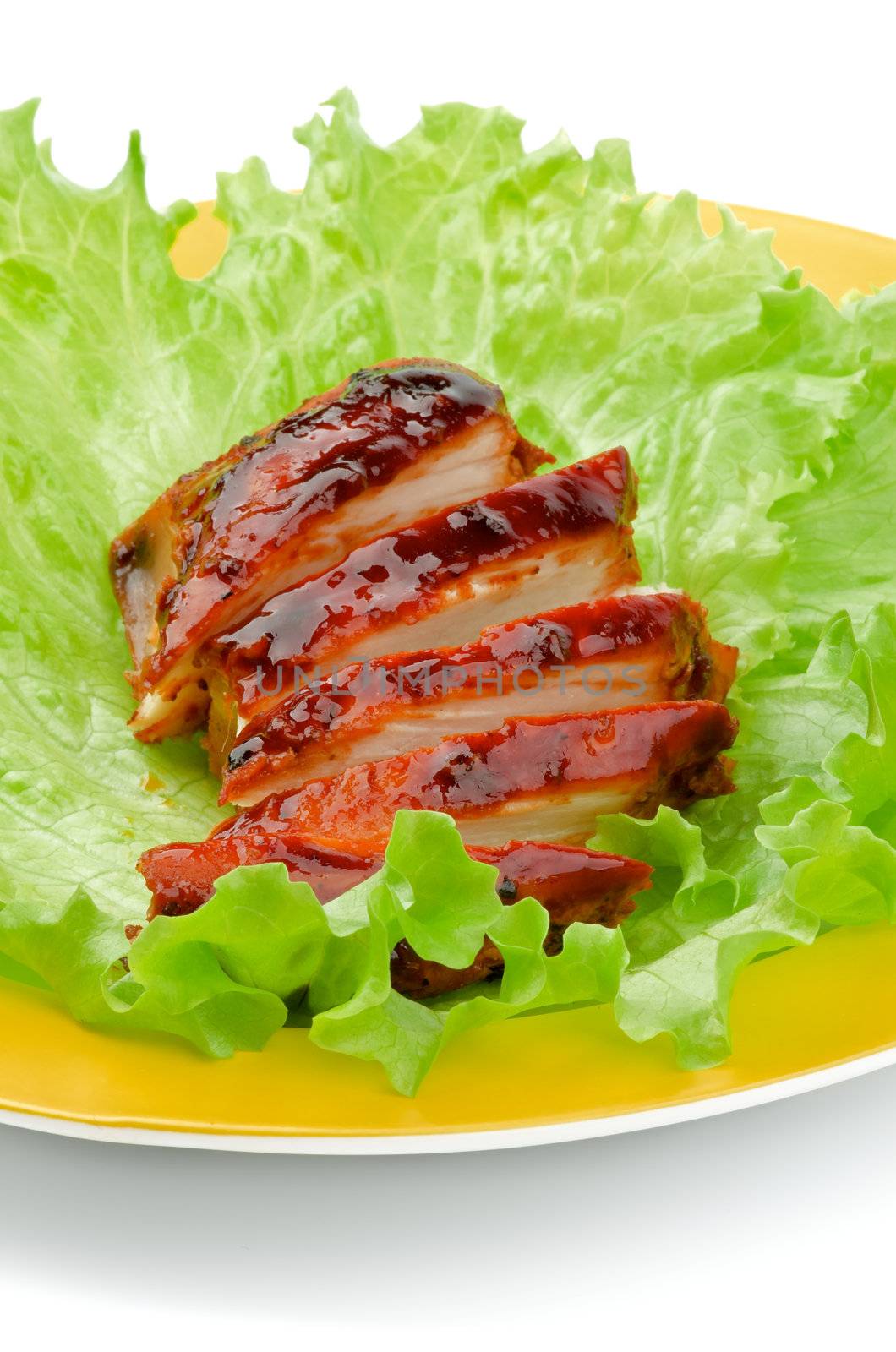 Sliced Barbecue Chicken Breast with Lettuce on Yellow Plate closeup