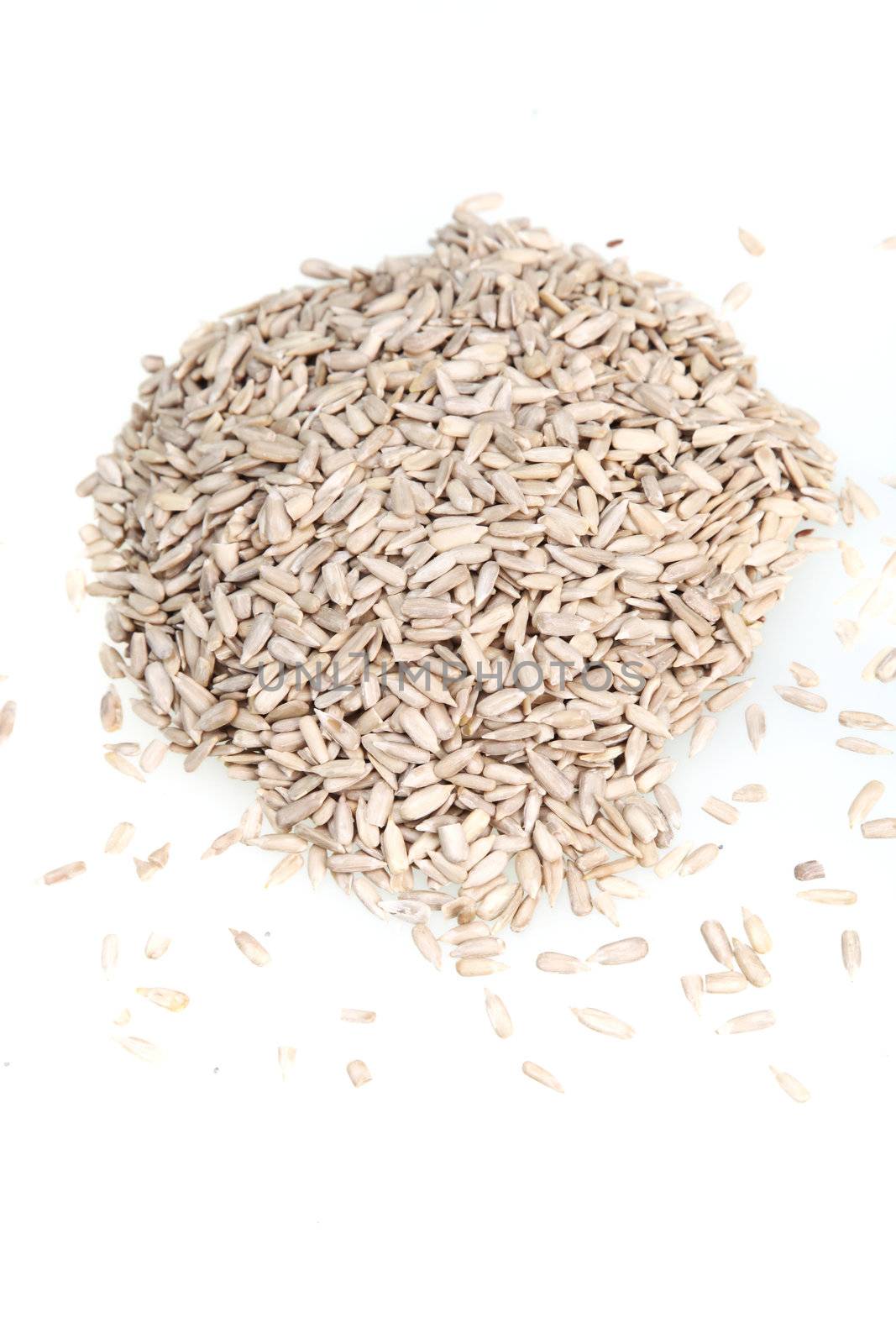 Pile of dehulled sunflower raw seed kernels on a white background for use as an ingredient in cooking or to produce sunflower oil