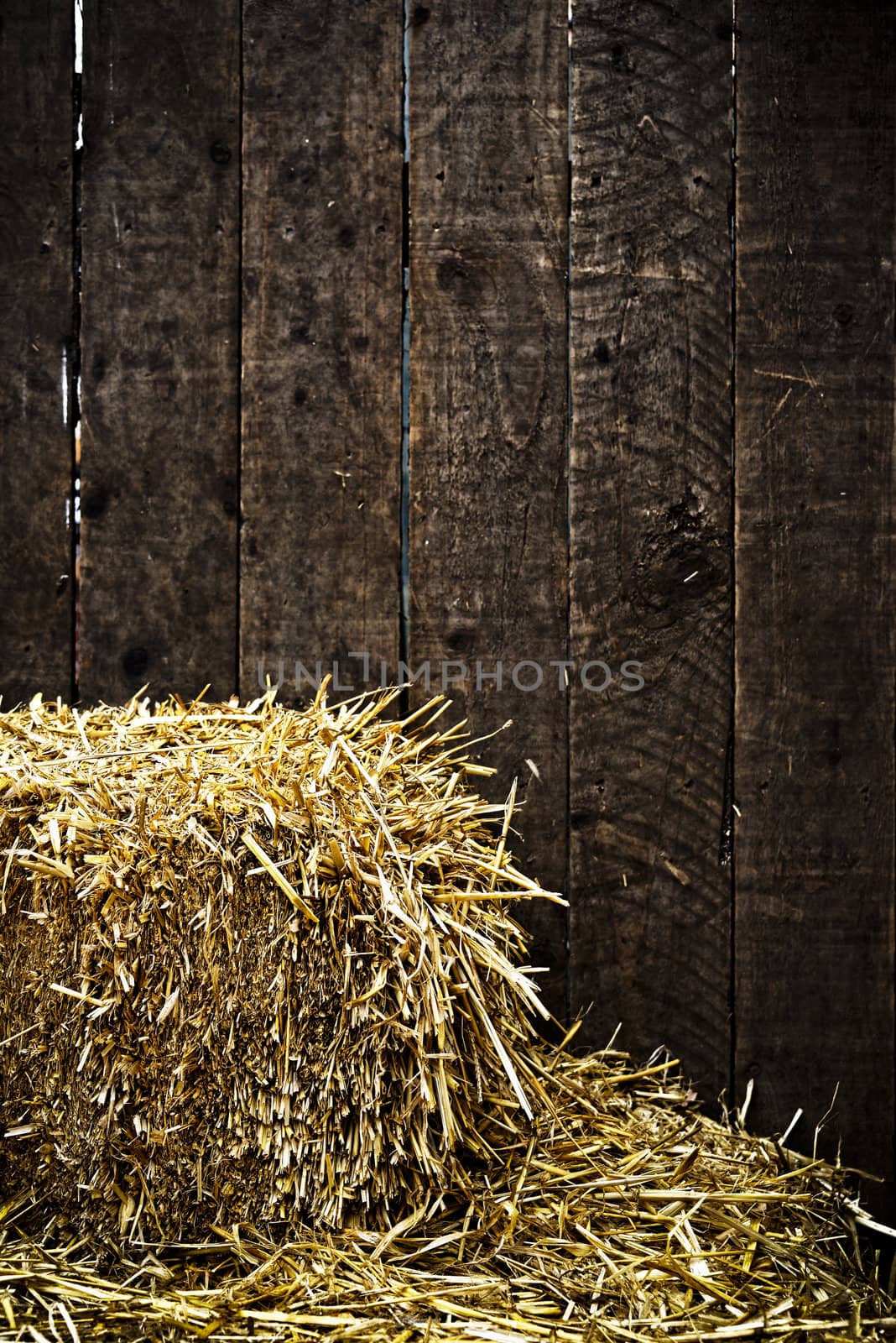 Bale of straw and dark wooden background with vignette