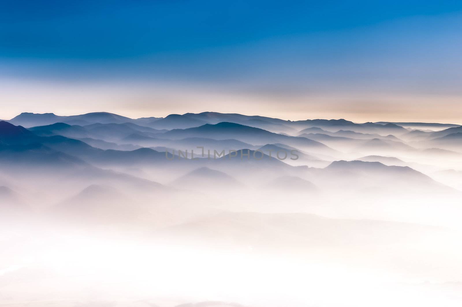 Misty mountains magical landscape view with blue sky