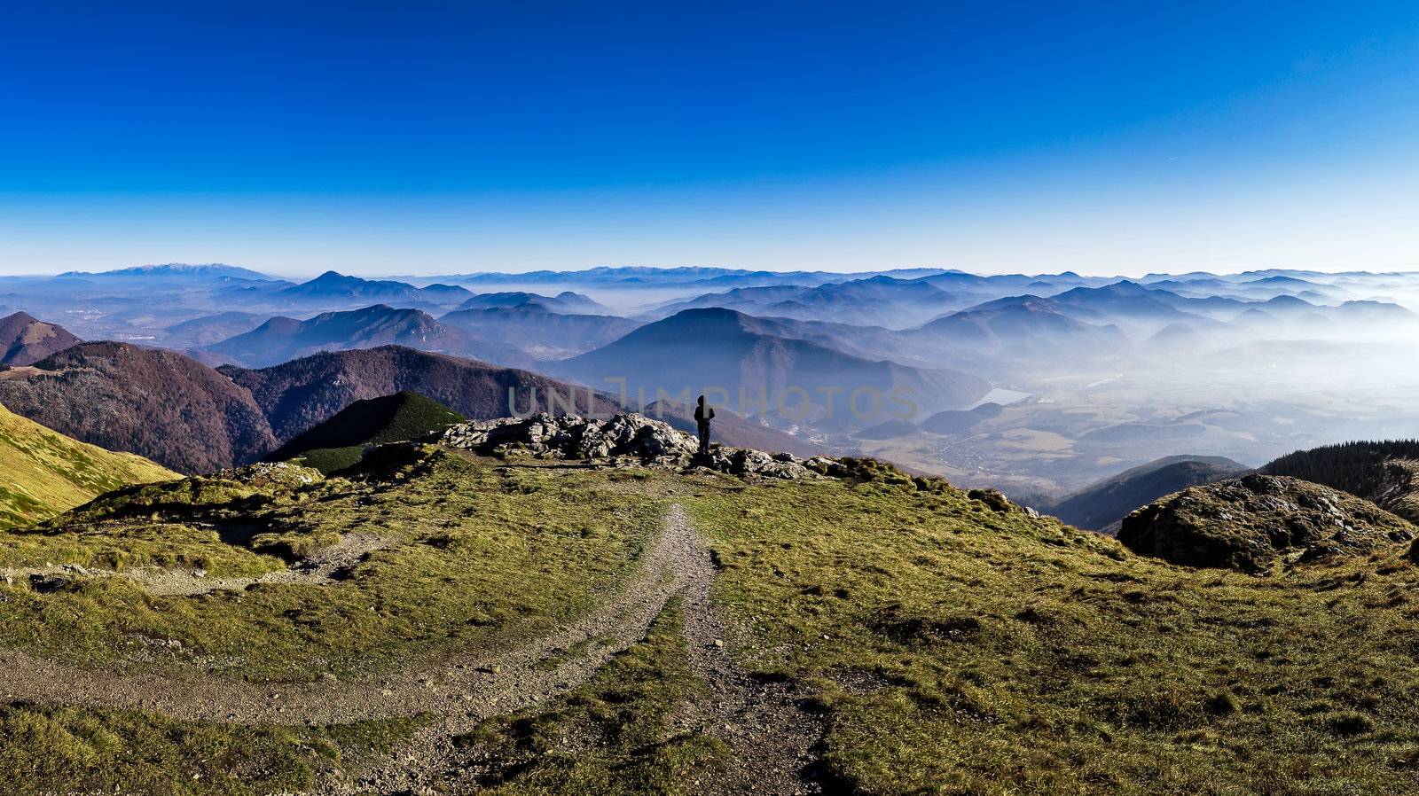 Silhouette of a man overlooking misty mountains by martinm303