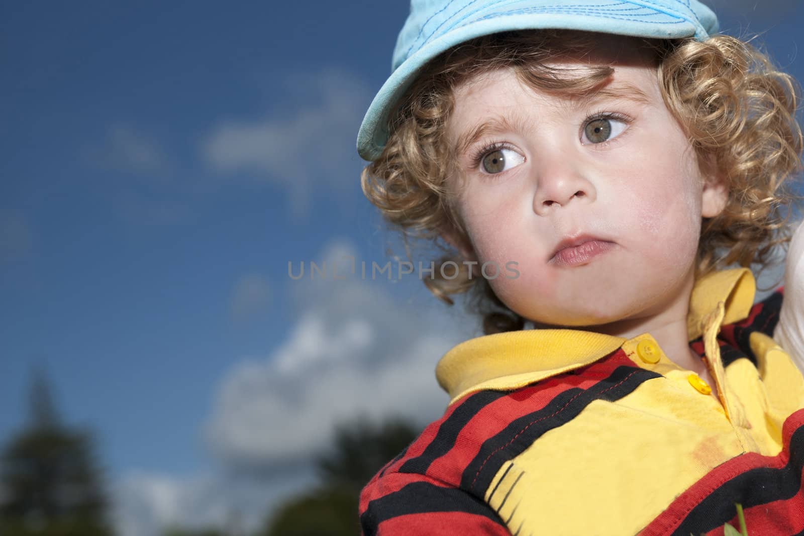 Small cute boy in blue cap, closeup.