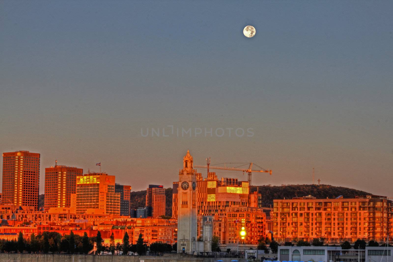 Sunrise with full moon over Montreal cityscape