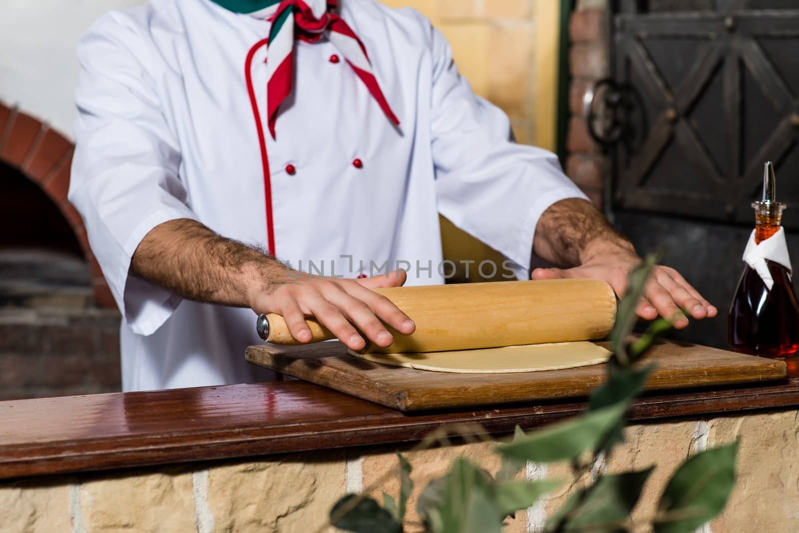 Cook rolls out the dough on a board by adam121