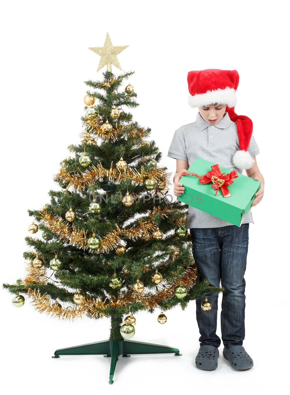 surprised boy in santa hat with christmas present on white background