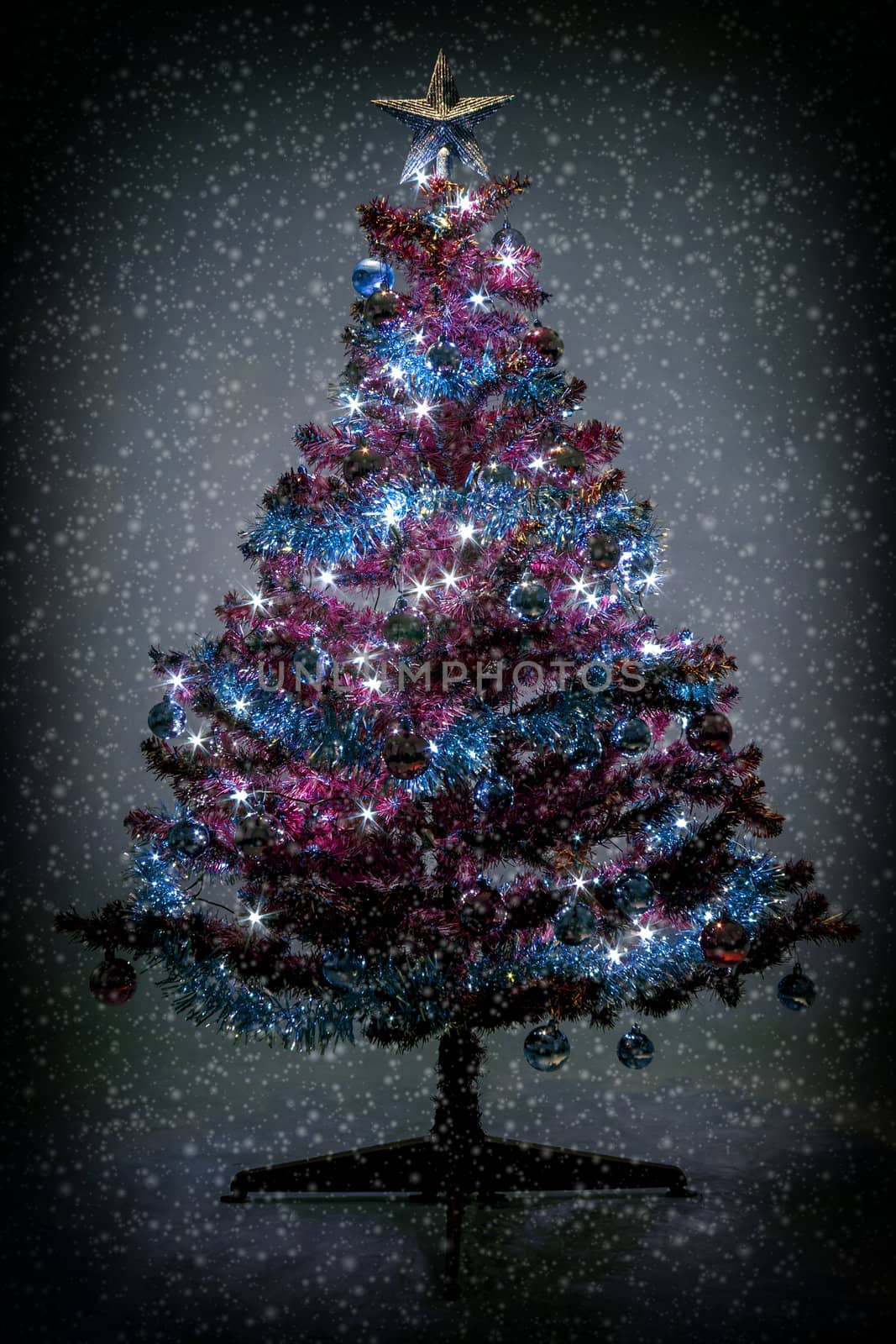 Abstract color toned christmas tree with glowing lights and snowflakes