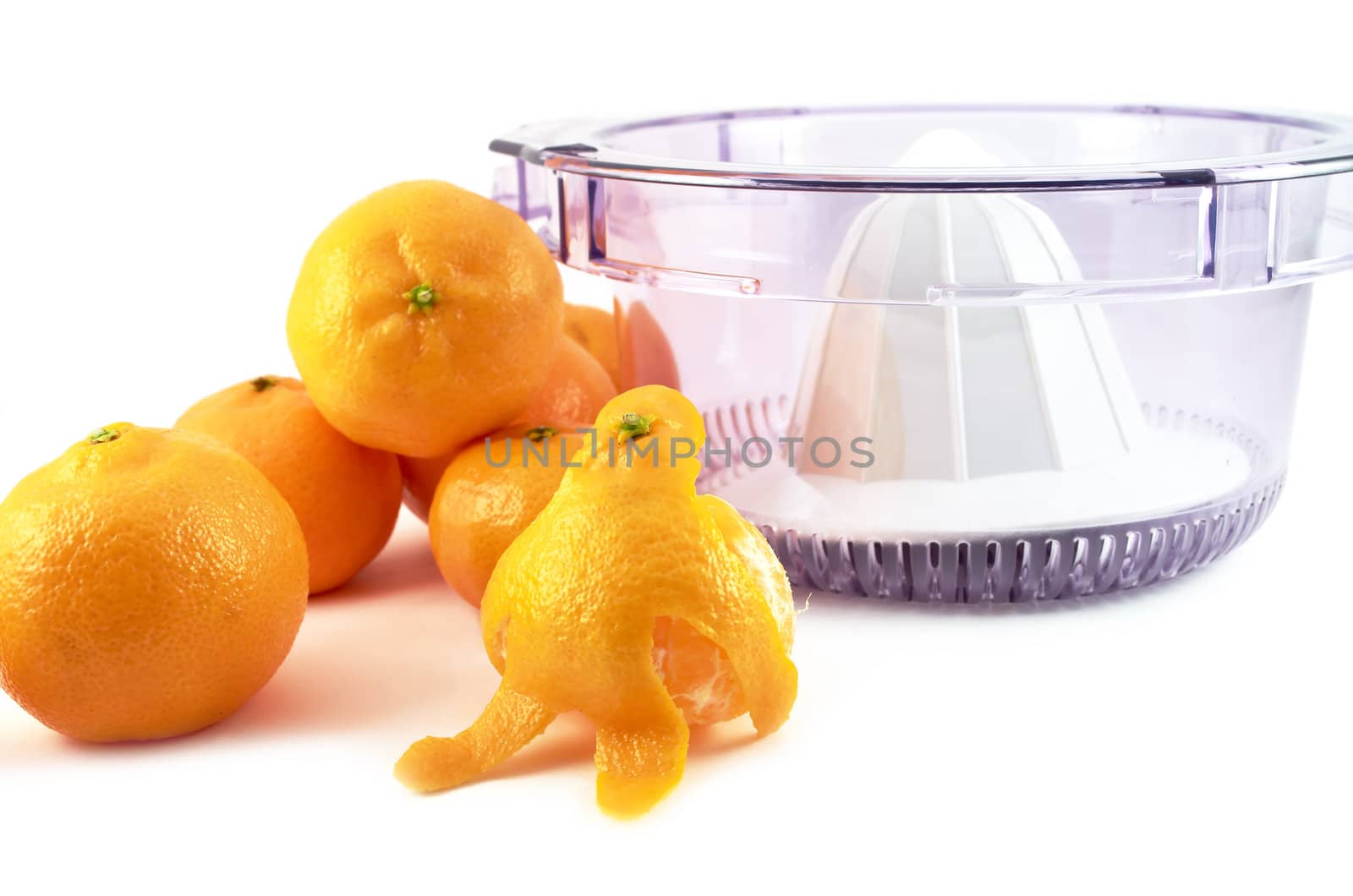 Tangerines and man made ​​out of mandarin near the juicer