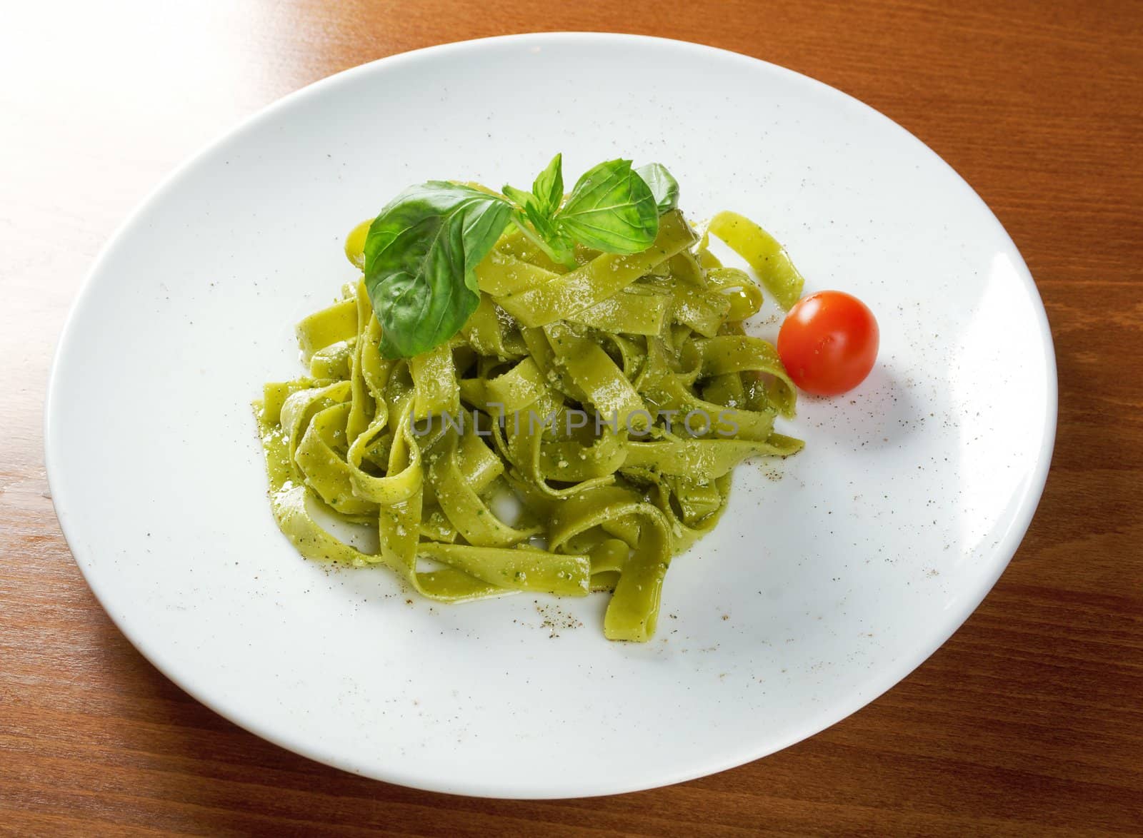 Tagliatelle pasta with pesto on light plate. closeup