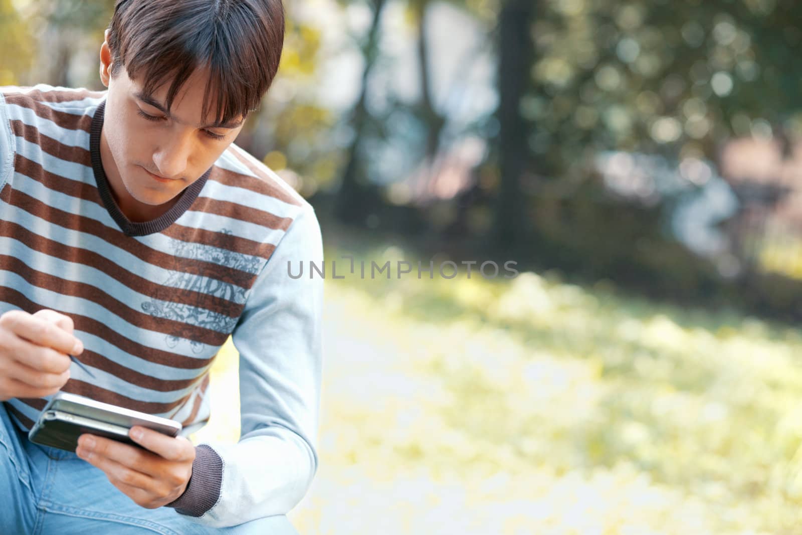 Young man using a PDA outdoors