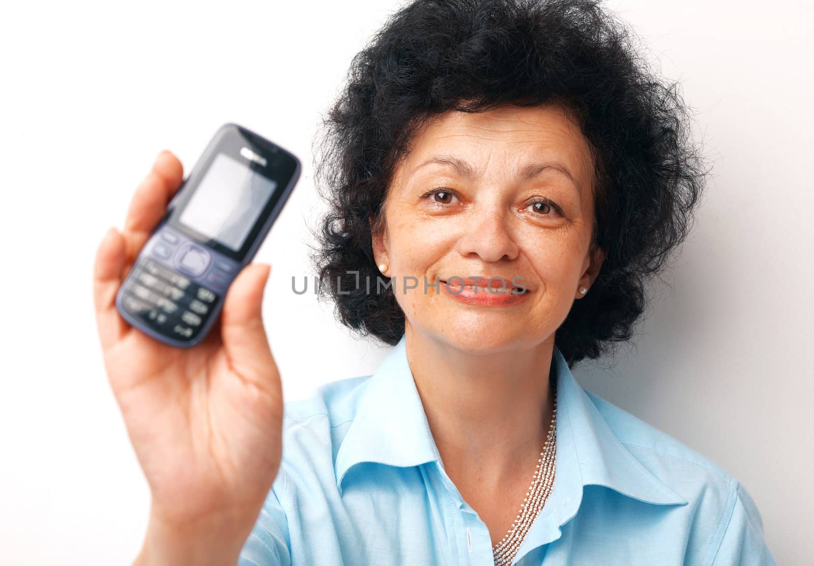 Close-up of an elder smiling woman holding and showing her mobile.