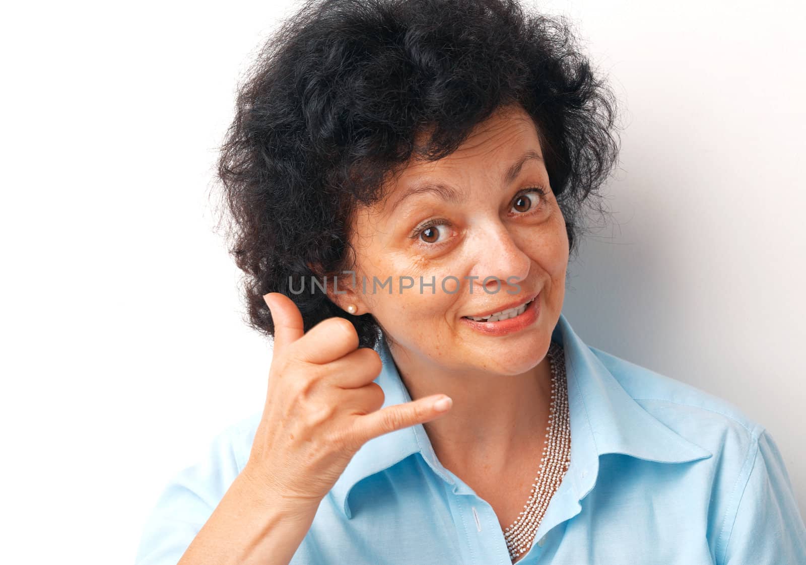 Close-up of an elder woman showing a sign "call me" over white background.