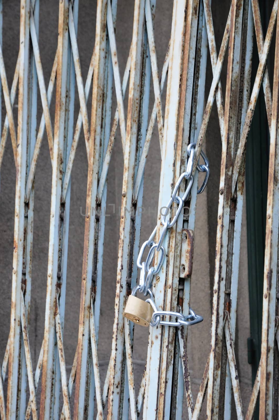 Closed padlock with a chain on a metallic grid
