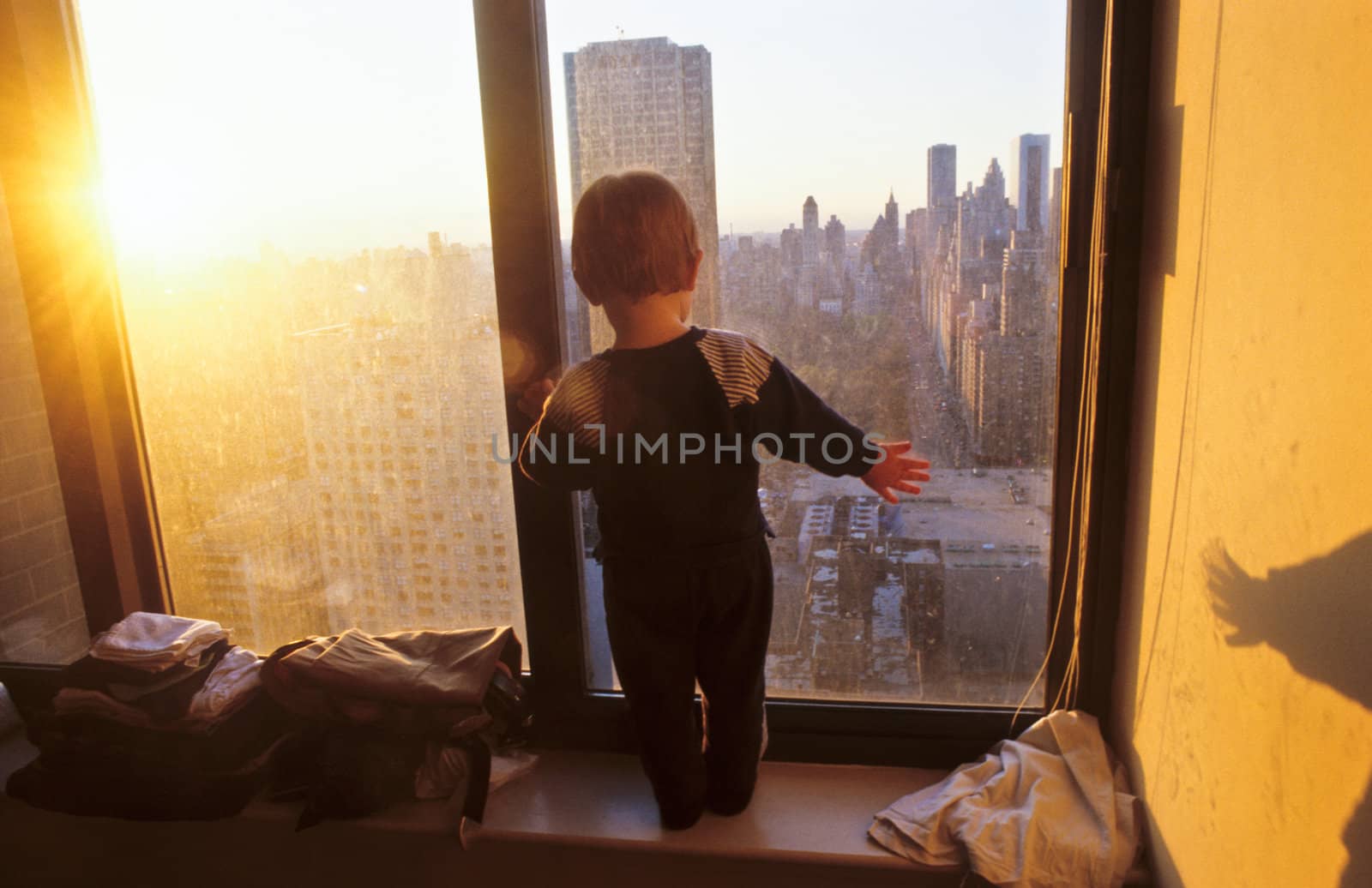 young boy looks fascinated from the skyscraper to the streets of by meinzahn