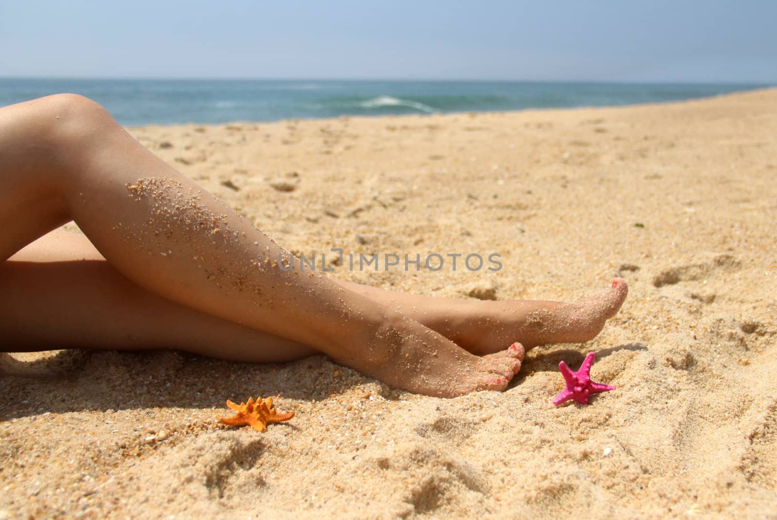 Beautiful female legs on the beach by tanouchka